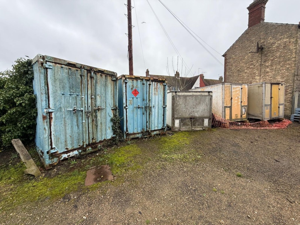 Lot: 77 - TWO PLOTS OF FREEHOLD LAND - Left side of land showing containers